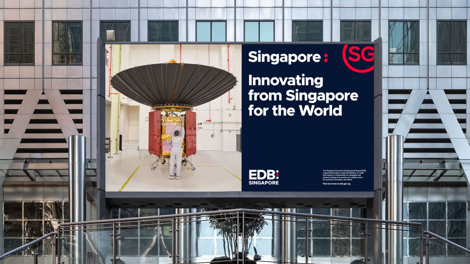 EDB “Innovating from Singapore for the World” billboard in a glass-and-steel atrium